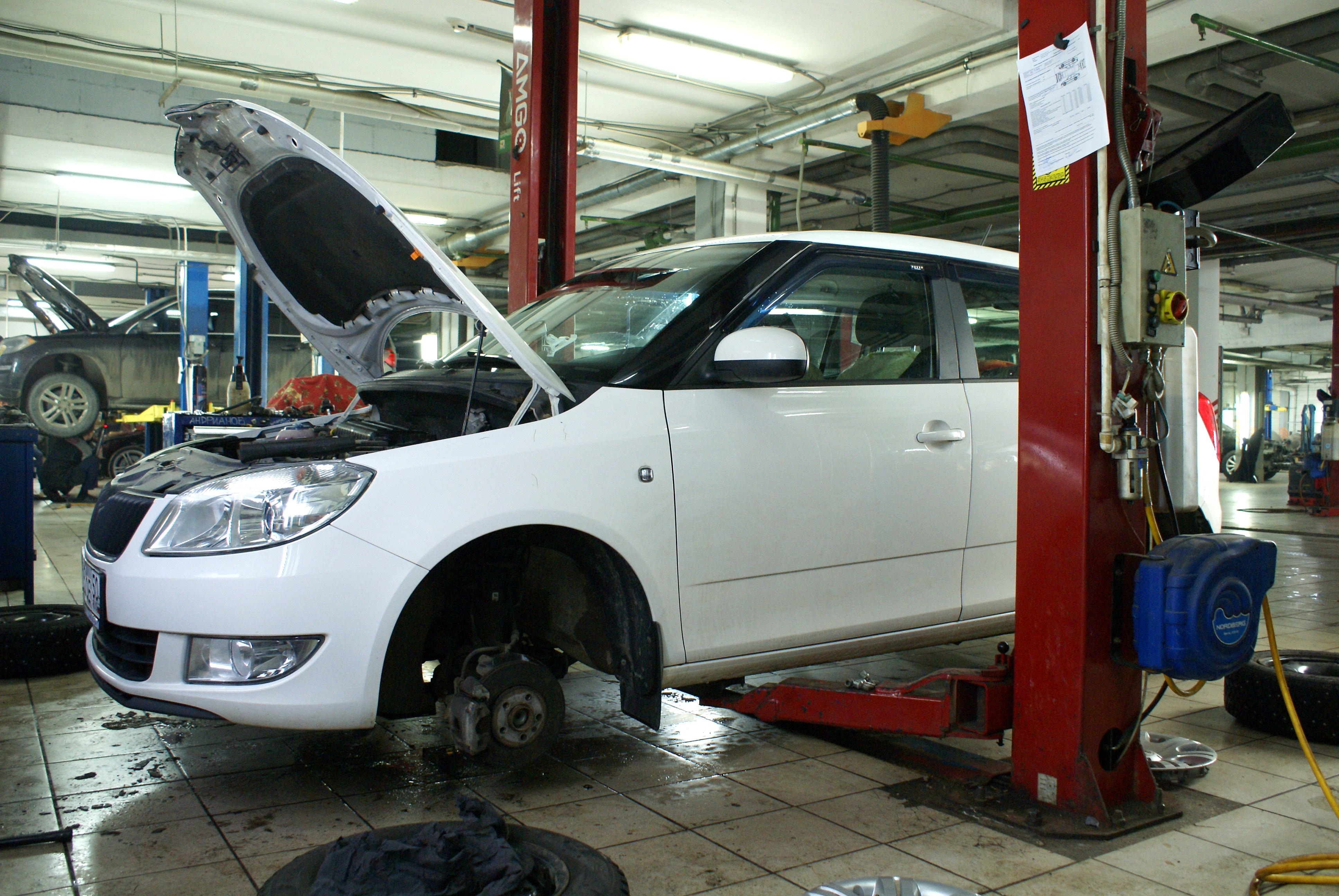 белая Шкода в сервисе на подъемнике